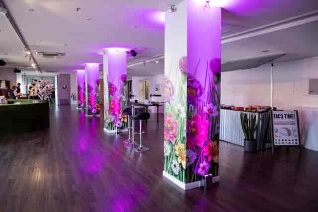 OXO2 event space with floral columns, purple lighting, and taco station for casual corporate parties.