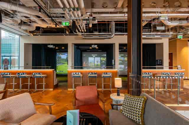 Modern industrial venue for corporate team building events with indoor golf simulators.