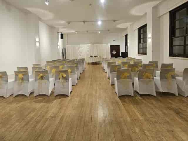Theater-style event room at Orchard Gardens Community Centre with gold-accented wedding seating.