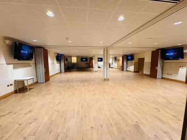 Versatile Front Lounge event space with wood floors, ideal for workshops and conferences.