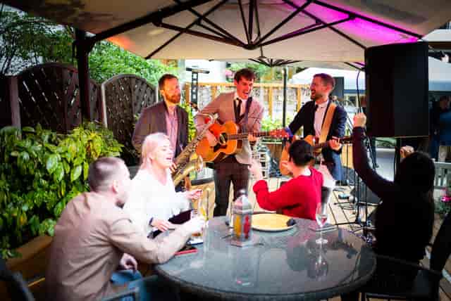 Outdoor evening reception with acoustic trio at Royal Over-Seas League, London event venue.