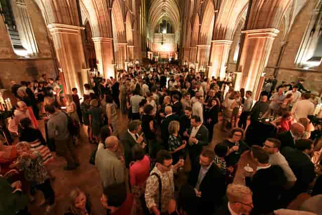 Vibrant networking event in Southwark Cathedral's grand nave with high ceilings.