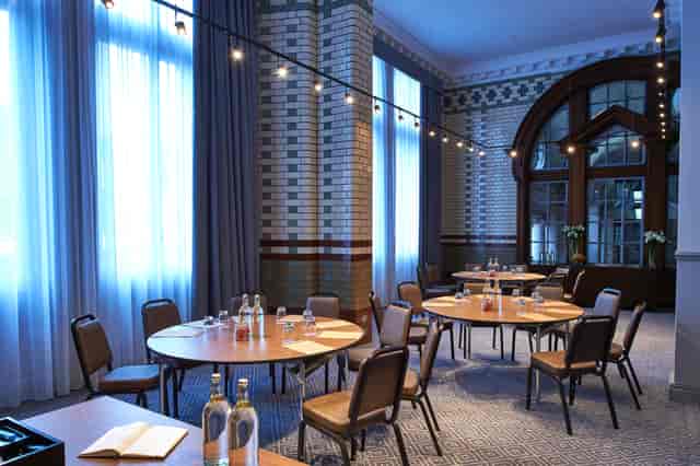 Elegant meeting space with round tables at Kimpton Clocktower Hotel for workshops and conferences.