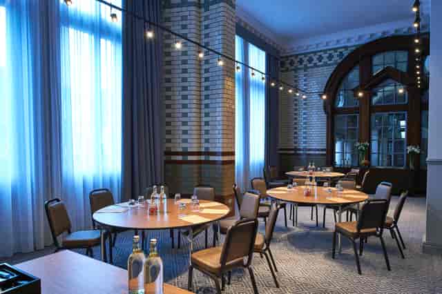 Elegant meeting space with round tables at Kimpton Clocktower Hotel for workshops and conferences.