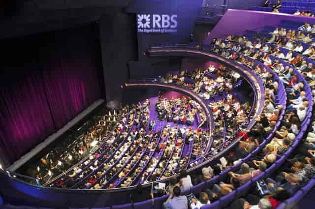 Lyric Theatre auditorium set for corporate events with tiered seating and branding.