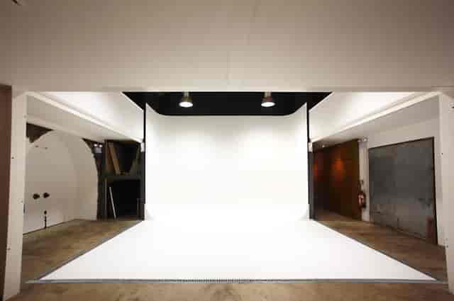 Versatile event space at Canvas Works with white backdrop, ideal for workshops and presentations.