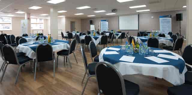 First Floor Hall at King's House: organized meeting space with round tables for professional events.