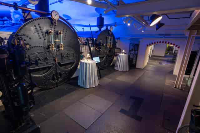 Networking event at Tower Bridge Engine Rooms with industrial decor and accent lighting.