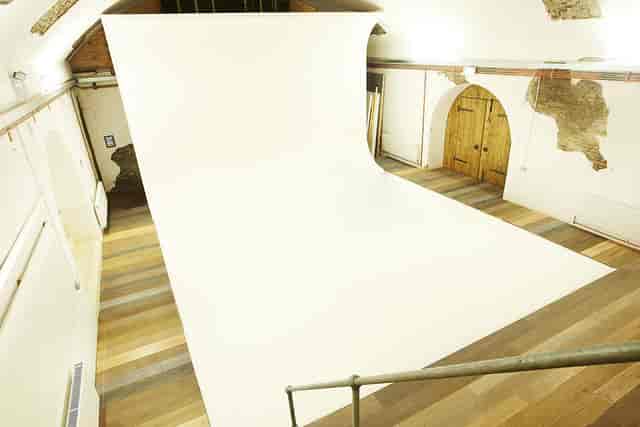 Versatile event space with blank backdrop and sleek flooring for presentations and workshops.