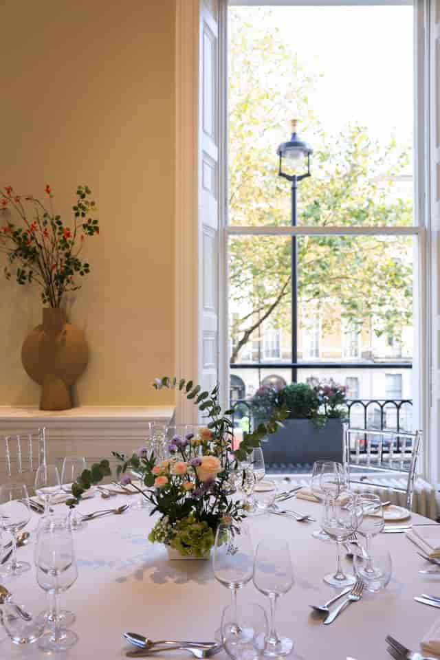 Elegant London event venue, floral table setting, corporate dinner, VIP reception.