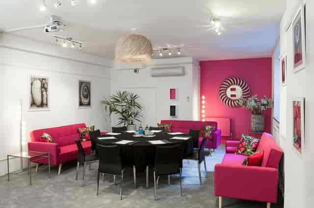 Modern Bauhaus London breakout room with round table for creative meetings and strategy events.