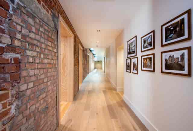 Modern corridor in Toynbee Hall, ideal for networking events with exposed brick and wood.