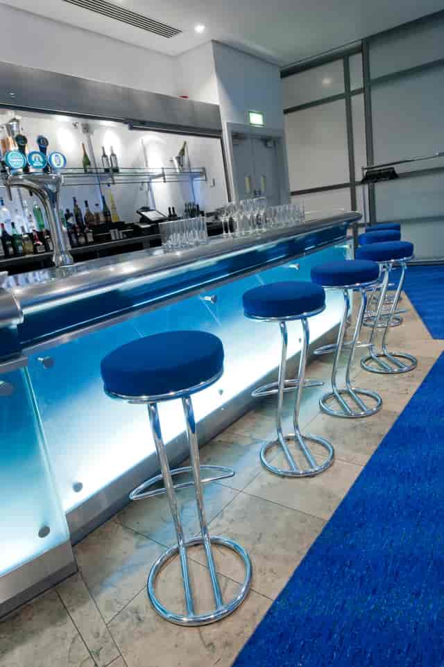 Barbirolli Room bar setup with blue stools, ideal for networking events and cocktail receptions.