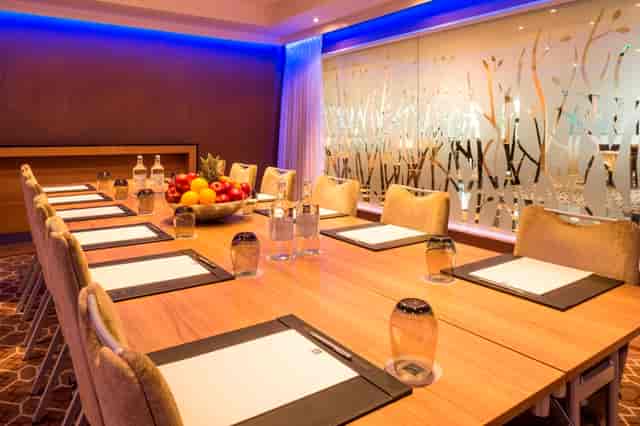 Private dining room at Chelsea Harbour Hotel with wooden table, ideal for meetings and events.
