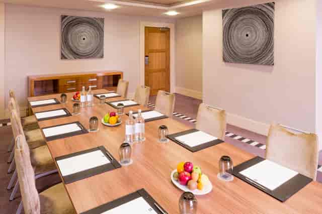 Albert Suite meeting room at Chelsea Harbour Hotel, featuring a long wooden table and natural light.