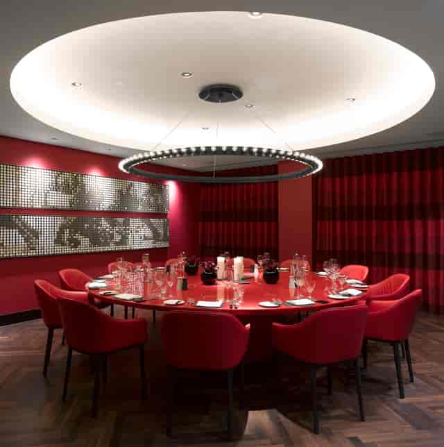 Sophisticated meeting space at South Place Hotel with round table and vibrant red decor.