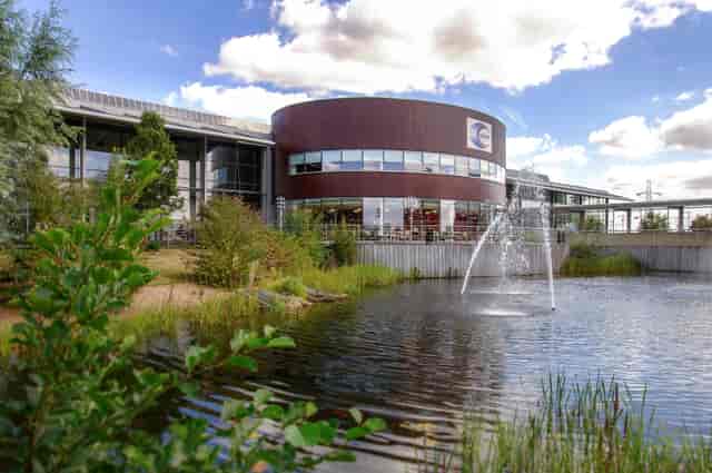 Modern event venue with greenery and water feature, ideal for corporate meetings and gatherings.