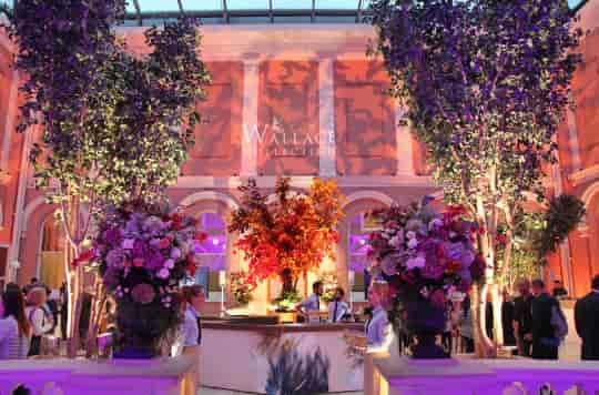 Elegant event space in The Wallace Collection with floral arrangements and ambient lighting.