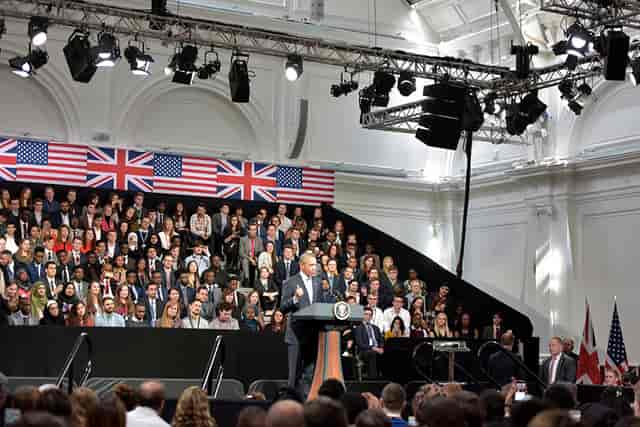 Lindley Hall event with speaker at podium, flags backdrop, audience engagement.