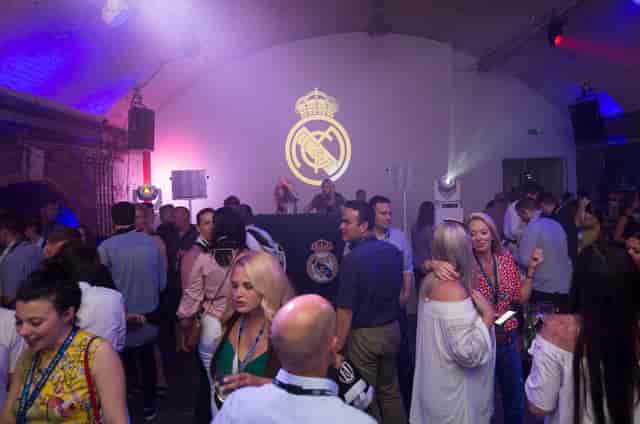 Vibrant corporate event in Shoreditch Studios with Real Madrid branding and DJ setup.