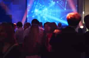 Vibrant networking event in Shoreditch Studios with dynamic lighting and modern tech.