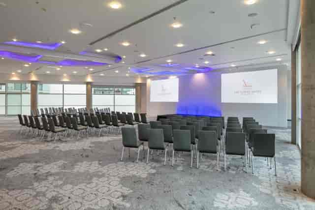 Grand Ballroom theater-style setup with purple lighting for corporate conferences and keynotes.