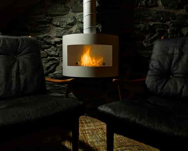 Cozy venue with black leather chairs and fireplace, ideal for meetings and brainstorming.