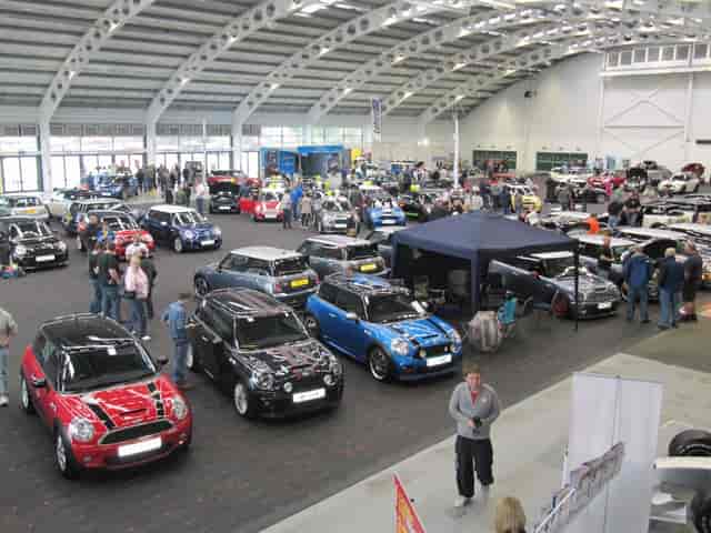 Aintree Racecourse indoor car show with organized displays and vibrant attendee engagement.