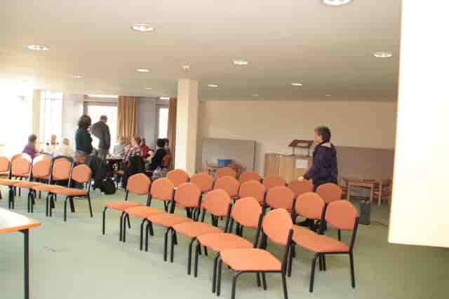 Institute Room in Liverpool Quaker Meeting House with orange chairs for gatherings.