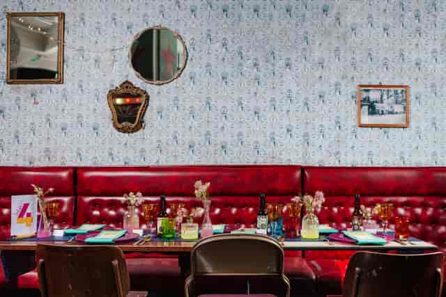 Vibrant event space at The Big Top, featuring a long table and red seating for gatherings.
