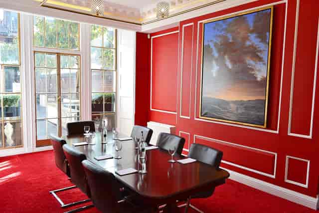 Ruby Salon meeting room with wooden table, black chairs, ideal for corporate events.
