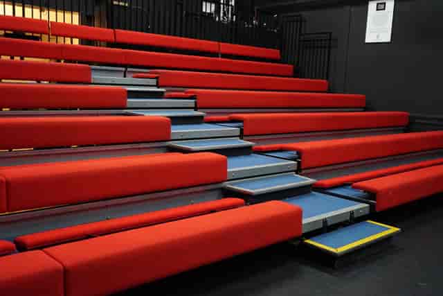Red tiered bleachers in Young Actors Theatre Islington for events and performances.