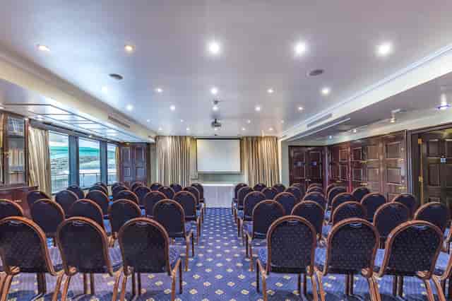 Club Library meeting room with chairs and projection screen for corporate events.