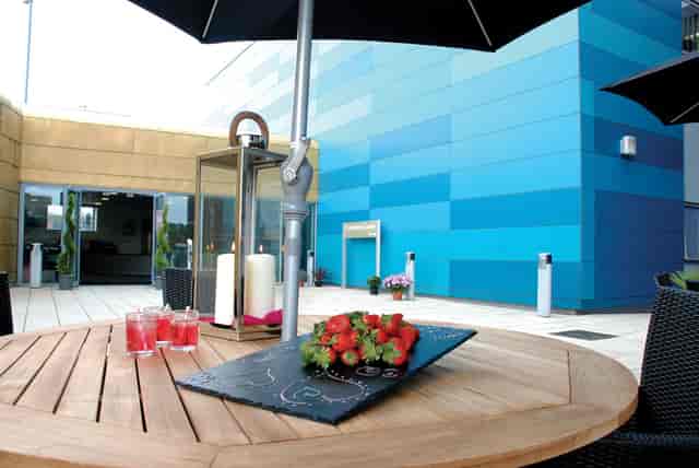 Stylish outdoor event space at Bournville College with wooden table and fresh strawberries.